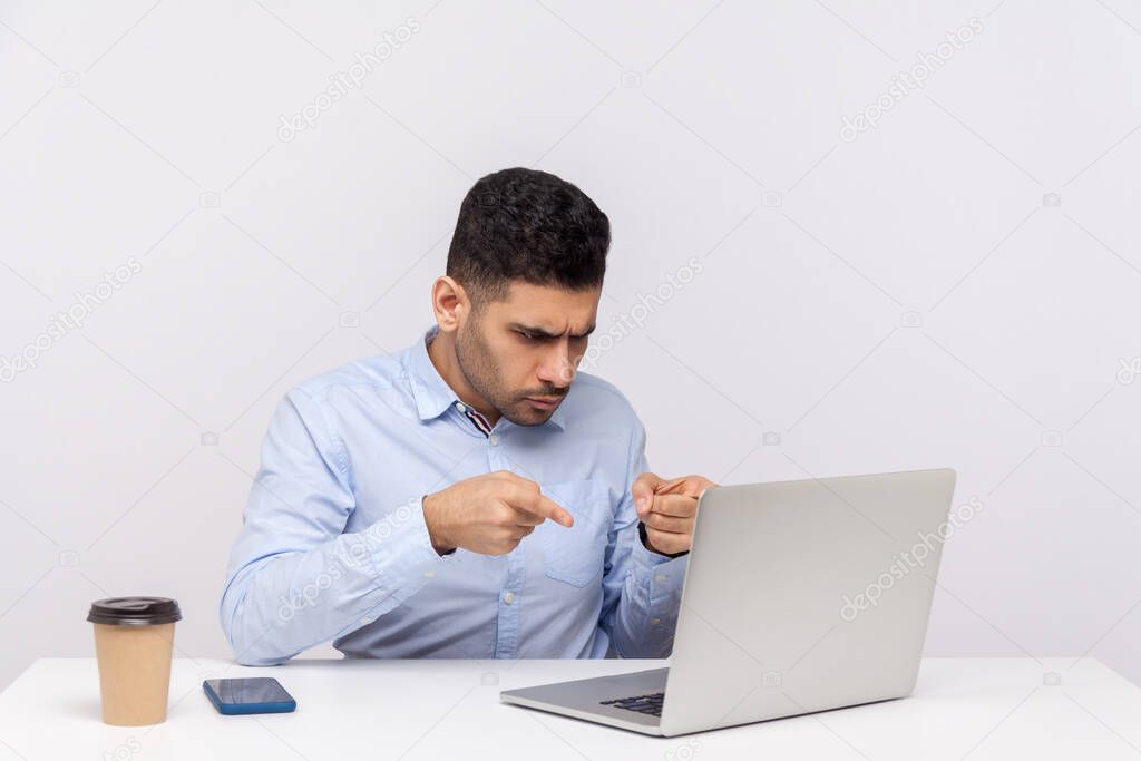 Hey you! Angry strict businessman sitting office workplace, pointing fingers to laptop screen, scolding blaming partner on video call, online conversation. studio shot isolated on white background
