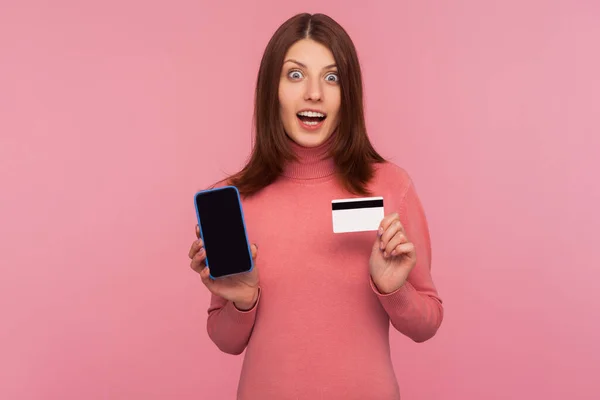 Mujer Morena Sorprendida Suéter Rosa Que Muestra Teléfono Celular Tarjeta — Foto de Stock