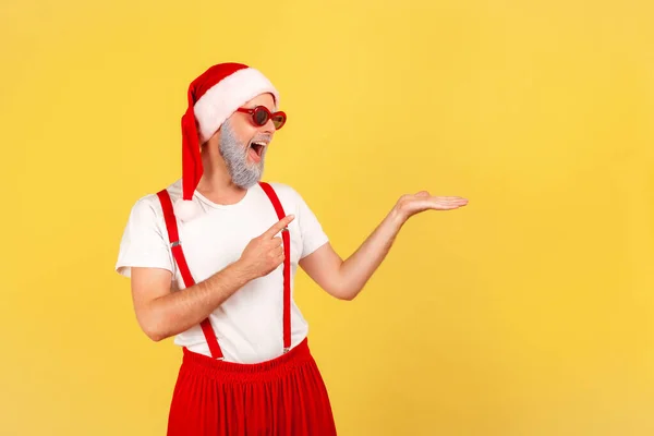 Hombre Anciano Positivo Gafas Sol Sombrero Santa Claus Señalando Con —  Fotos de Stock