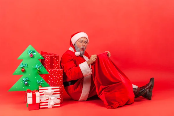 Surpreendido Papai Noel Sentado Chão Sob Papel Decorado Árvore Natal — Fotografia de Stock