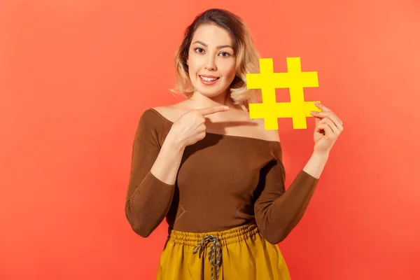 Positiivinen Houkutteleva Nainen Bloggaaja Osoittaa Sormella Iso Keltainen Hashtag Kädessään — kuvapankkivalokuva