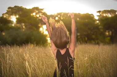 vahşi Field'da uzanmış kolları olan genç kadın