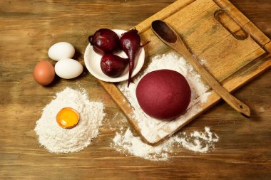 Masadaki malzemeli erişteler için mor hamur çöreği..