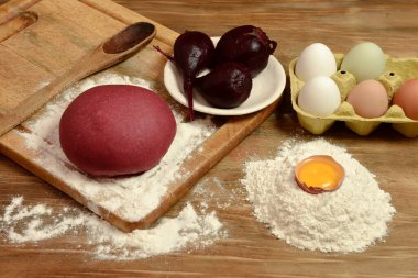 Masadaki malzemeli erişteler için mor hamur çöreği..