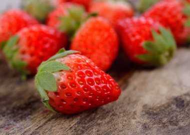 Eski ahşap arka planda taze çilekler.