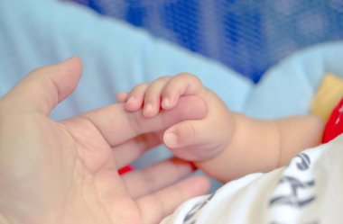 Aşk ve aile kavramı. Anne ve bebeğin elleri yakın plan