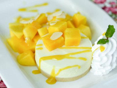 Mango cheesecake beyaz plaka üzerinde