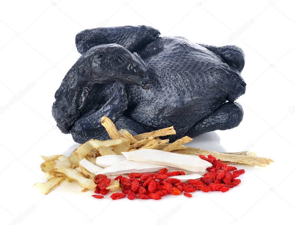 Black chicken with Chinese herbs on white background.