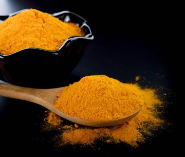 siyah arka plan üzerinde zerdeçal tozu.