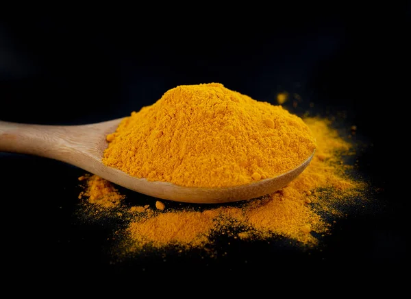 siyah arka plan üzerinde zerdeçal tozu.