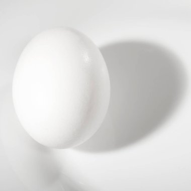 Beyaz yumurta beyaz bir arka plan üzerinde beyaz bir plaka üzerinde.