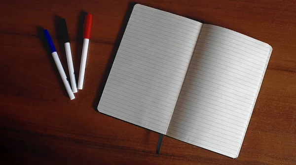 Ofis Masası ahşap arka plan hakkında defter ve işaretleri beyaz kağıt