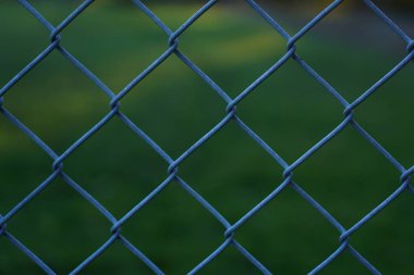 Zincir bağlantı çit ile bulanık yeşil çim arka plan desenini