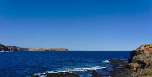 Ruhiges Meer mit blauem Himmel im Hintergrund — Stockfoto