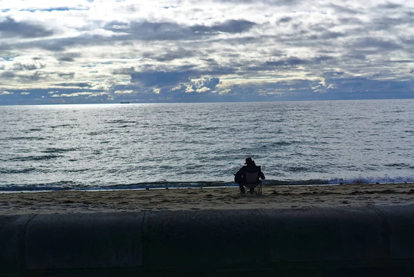 Man sitting facing sea — Stock Photo, Image