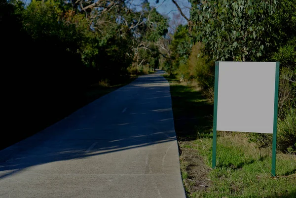 Tablero en blanco junto a la carretera de asfalto — Foto de Stock