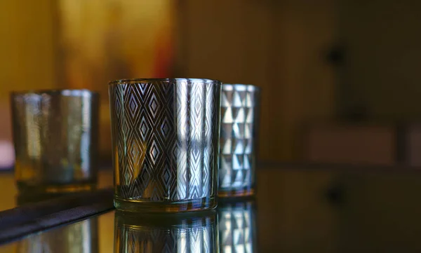 Silver whiskey tumbler on glass top surface
