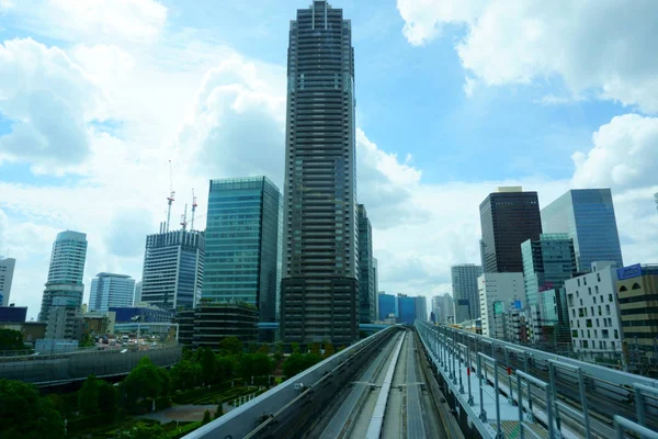 Yurikamome Line in Tokyo with background of modern buildings in Odaiba under blue clear sunny sky