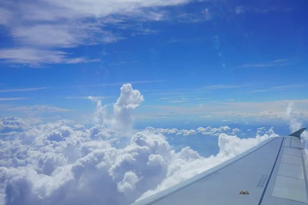 Ala de avião no céu. Vista do pórtico do avião. Céu azul bonito com nuvens — Fotografia de Stock