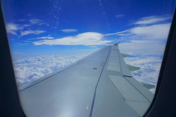 Ala de avião no céu. Vista do pórtico do avião. Céu azul bonito com nuvens — Fotografia de Stock