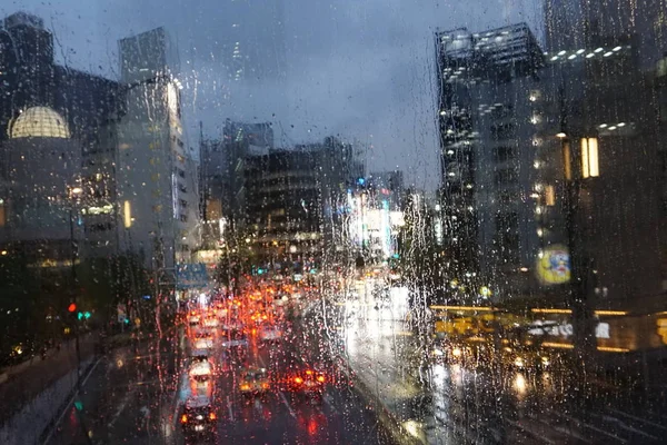 Rainy evening in the city. Raindrops on glass. Tokyo, Japan