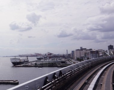 Tokyo / Japonya - 12 Eylül 2018: Yurikamome Tren demiryolu sistemi. Okyanus görüş kesinlikle çarpıcı ve yolcu lüks tekne ve büyük kargo gemileri görmek alacak