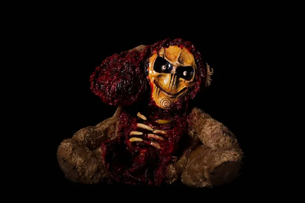 Halloween toy. a bear cut to the bone. bloodied. isolated on a black background