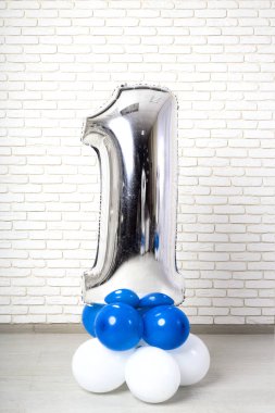 büyük gümüş şekil. bir balondan bul. bir tane. beyaz duvara karşı