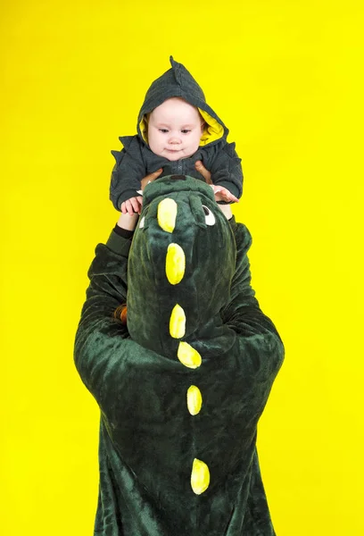 Mutter und Tochter im lustigen Drachenkostüm. Spiel auf einem gelben Bac — Stockfoto