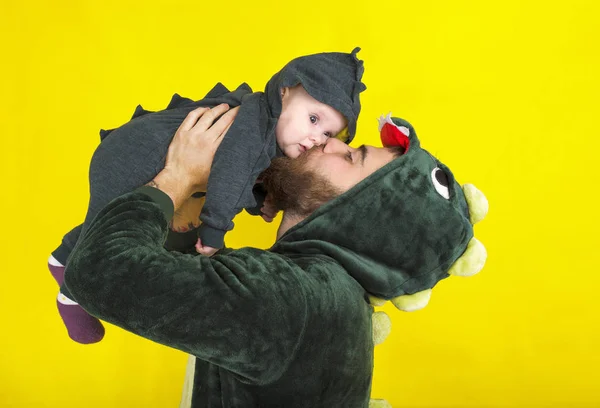 Смешные папа и дочь в костюме дракона. на желтом фоне — стоковое фото