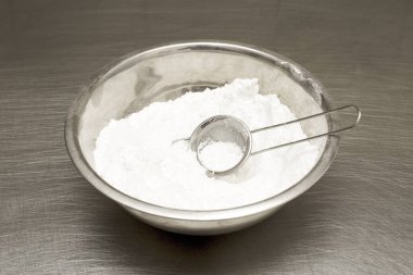 bir kapta un. Elemek. mutfakta masada