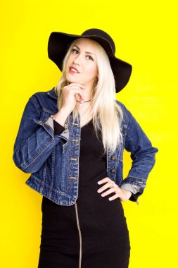 bir şapka ve kot ceket güzel sarışın kız üzerinde gülümsüyor 