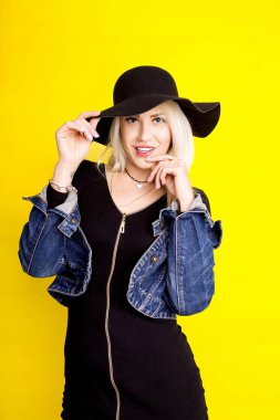 bir şapka ve kot ceket güzel sarışın kız üzerinde gülümsüyor 