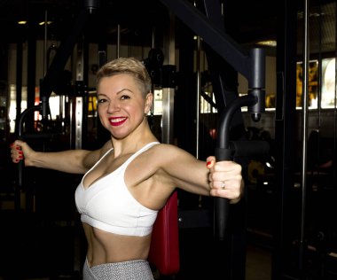 sarışın kız spor salonunda eğitim. üzerinde bir egzersiz yapar 