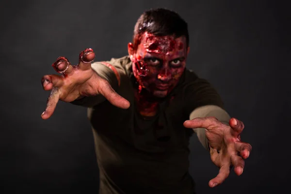 Straszny zombie z ranami szarpanymi. Krew. sięga po broń. zbliżenie — Zdjęcie stockowe