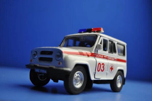 Çocuklar ve yetişkinler ilk yardım - ambulans mavi bir arka plan üzerinde için oyuncak metal araba