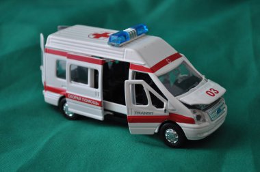 Çocuklar ve yetişkinler ilk yardım - ambulans yeşil bir arka plan üzerinde için oyuncak metal araba