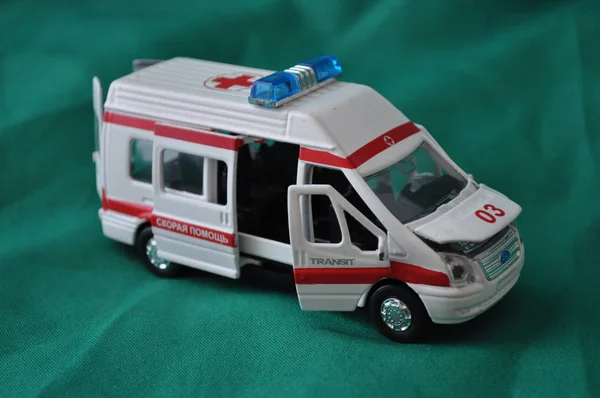 Çocuklar ve yetişkinler ilk yardım - ambulans yeşil bir arka plan üzerinde için oyuncak metal araba