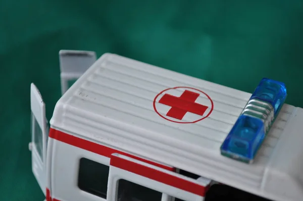 Çocuklar ve yetişkinler ilk yardım - ambulans yeşil bir arka plan üzerinde için oyuncak metal araba