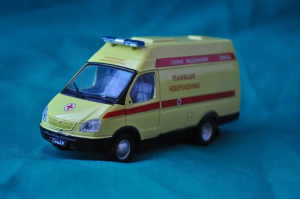Çocuklar ve yetişkinler ilk yardım - ambulans mavi bir arka plan üzerinde için oyuncak metal araba