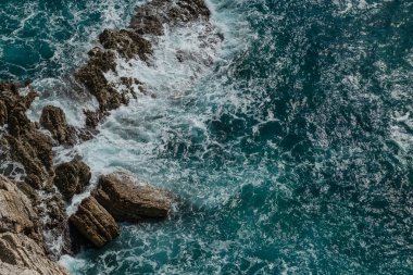 Mavi deniz dalgaları karşı kıyı kayalar dayak.