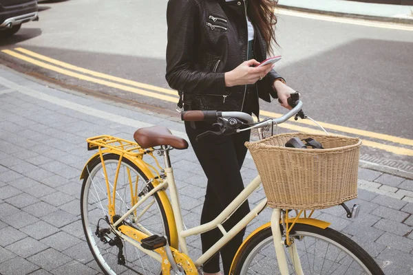 Sección Baja Mujer Sosteniendo Bicicleta Mientras Usa Teléfono Móvil Acera — Foto de Stock