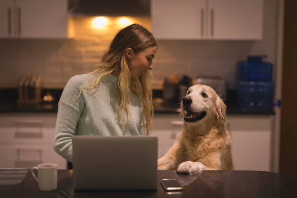 집에서 부엌에서 그녀의 강아지와 노트북을 — 스톡 사진
