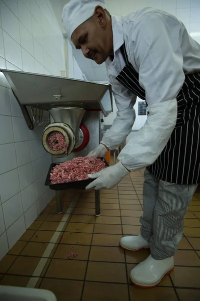 肉屋精肉店でミンチ肉にマシンを使用して — ストック写真