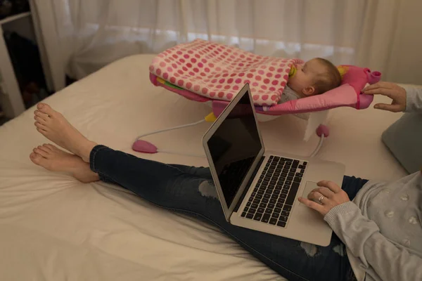 Mother Using Laptop While Baby Boy Sleeping Bed Home — Stock Photo, Image