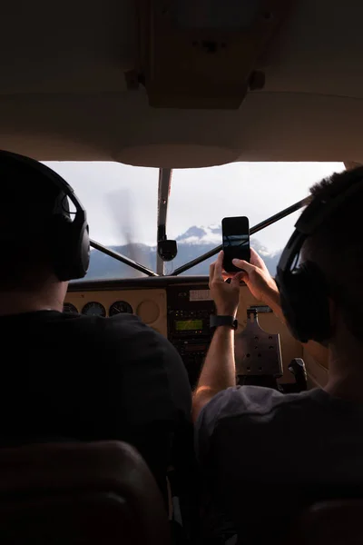 飞行员飞行飞机的后视 同时与手机拍照的副驾驶员 — 图库照片