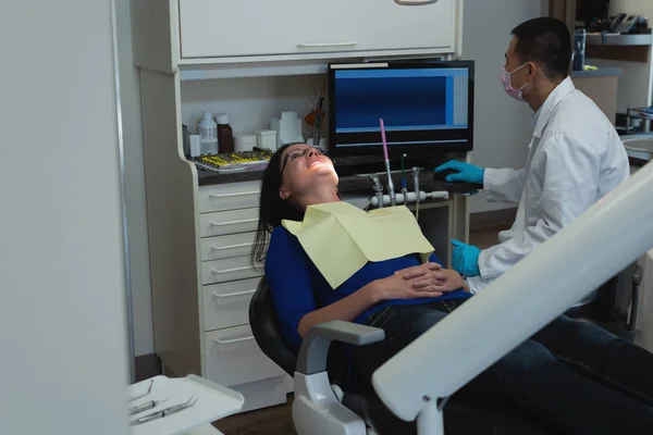 Mężczyzna Dentysta Przy Użyciu Komputera Stacjonarnego Badając Pacjenta Pani Poradni — Zdjęcie stockowe