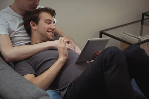 Sonriente Pareja Gay Usando Digital Tablet Juntos Casa —  Fotos de Stock