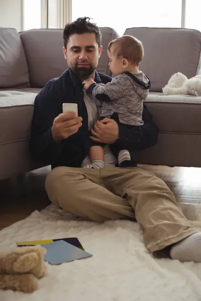 Vater Hält Sein Baby Bei Handy Nutzung Hause — Stockfoto