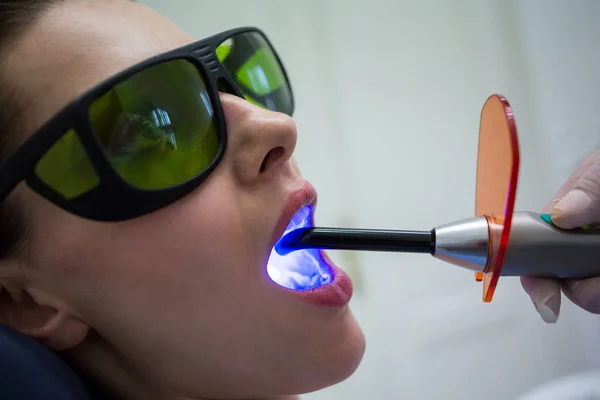 Dentista Examinando Dentes Paciente Com Luz Cura Dentária Clínica Close — Fotografia de Stock
